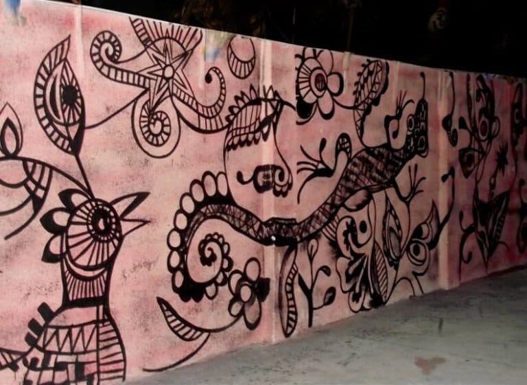 Parede decorada com desenhos artísticos em preto e rosa.